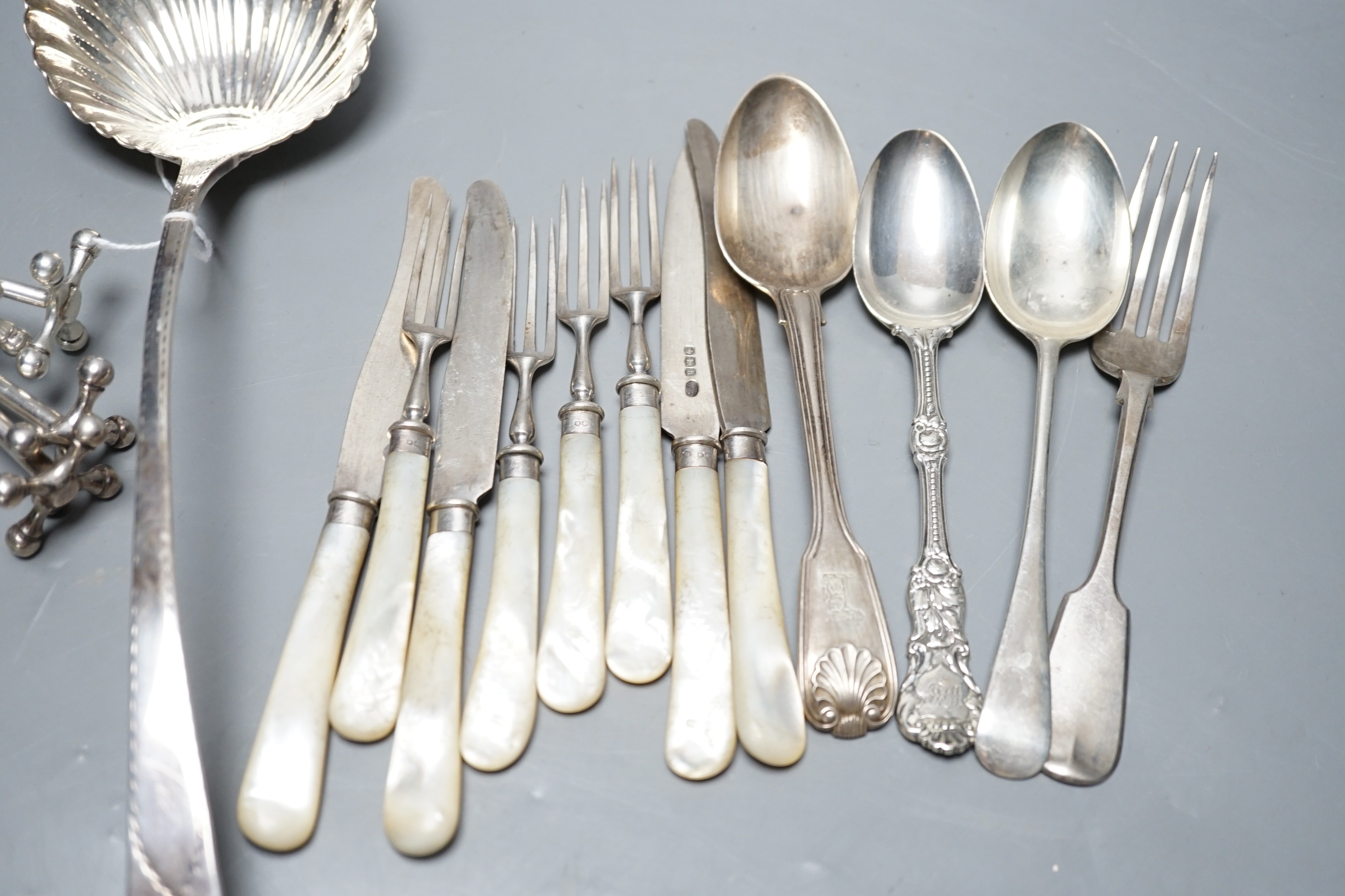 An 18th century silver Old English pattern soup ladle, marks rubbed,(a.f.), two pairs of silver knife rests including Mappin & Webb, Sheffield, 1915 and twelve other items of flatware.